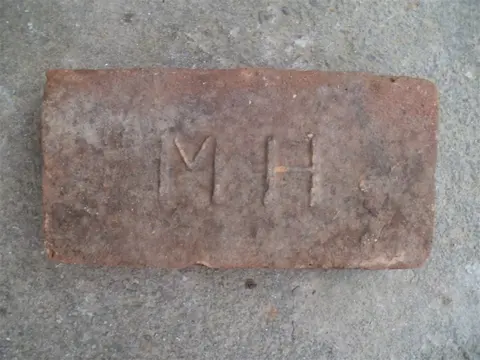 Značka M H